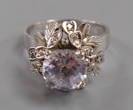 A modern white metal (tests as 18ct) and solitaire white sapphire set flower head ring, in a raised setting, size S/T, gross weight 8.1 grams.
